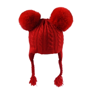 Red knit baby hat featuring double pom-poms and earflaps with braided tassels