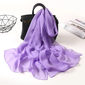 Detail view of a long purple chiffon scarf showing drape and texture on a leather bag