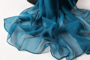 Detail shot of sheer dark teal georgette scarf fabric showing soft texture and drape