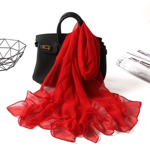 Elegant solid red georgette long scarf draped on a black handbag for sun protection