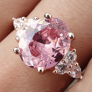 Macro shot of an oval pink gemstone ring with rose gold plating and side stones