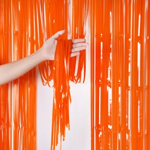 Close-up of orange plastic fringe curtain showing texture for Halloween party decoration