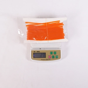 Macro shot of Halloween orange fringe curtain packaging weighed at 27g on digital scale