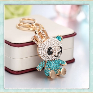 Exquisite panda keychain with blue crystals and gold crown detail on a jewelry box