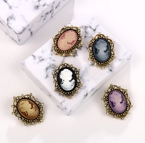 Detail of vintage cameo brooches featuring elegant lady portraits with rhinestone edges
