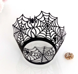 Macro shot of black laser-cut spider web cupcake wrappers for Halloween party decoration