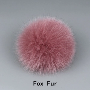 Gros plan détaillé du pompon en fourrure de renard rose montrant une texture douce