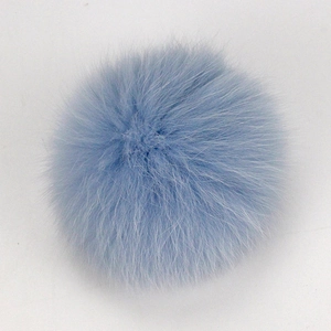Texture détaillée du pompon en fourrure de raton laveur bleu clair pour chapeaux