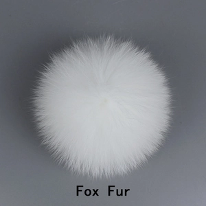 Close-up of a fluffy white fox fur pompom showing fine texture and soft animal hair