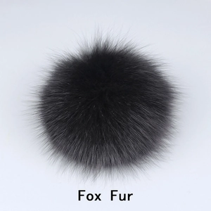 Gros plan d'un pompon noir en fourrure de renard pour chapeau et sac