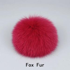 Detail shot of fluffy fuchsia fox fur pompom with soft texture for hat accessories