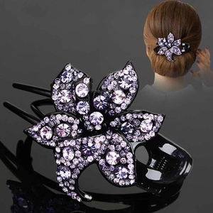 Detailed view of flower hair comb with purple rhinestones and three-tooth resin grip