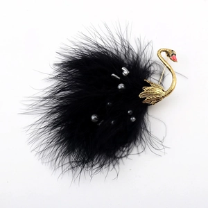 Detail of elegant black swan brooch featuring soft ostrich feathers and gold metal accents