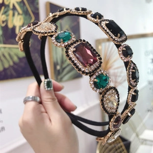 Macro detail of luxury baroque headbands with vibrant emerald and multi-color crystals