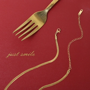 Detail of gold snake chain necklace with lobster clasp and adjustable extender chain