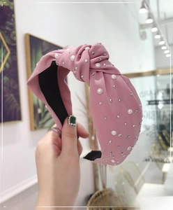 Detail of pink knotted headband featuring white pearls and silver rhinestones