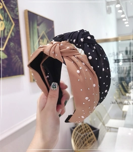 Detailed close-up of knotted wide headbands with elegant pearls and sparkling rhinestones