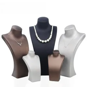 Close-up of matte leather necklace display busts in various heights for jewelry showcasing