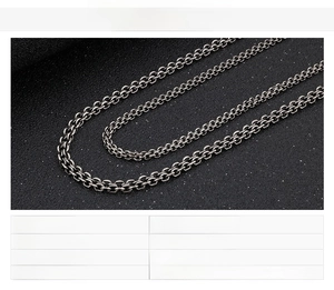 Macro detail of black stainless steel O-chain and cross chain for men with specs