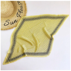 Detail of yellow pleated silk scarf with black geometric borders and summer straw hat