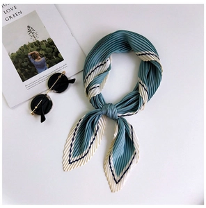 Detail of grey-green pleated silk scarf with contrasting cream edges and dark blue stripes