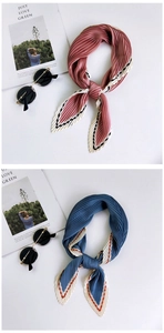 Detail of pleated silk scarves in lotus pink and misty blue with contrasting striped edges