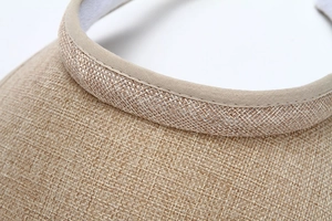 Close-up of khaki straw sun visor showing detailed woven texture and sewing craft