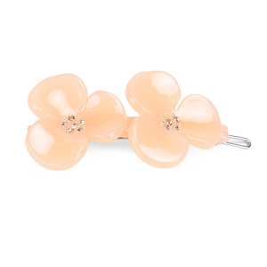 Close-up of pink petal hair clip with glossy resin finish and rhinestone flower center