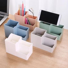 Close-up of trapezoid plastic desk organizers in five colors on a wooden table