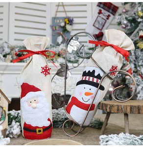 Detail of Christmas wine bottle covers featuring Santa and Snowman in linen fabric