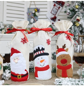 Close-up of burlap Christmas wine bottle covers featuring Santa, Snowman and Reindeer motifs