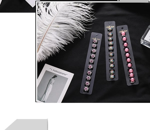 Détail d'un ensemble de boucles d'oreilles fleurs en strass et perles sur carte