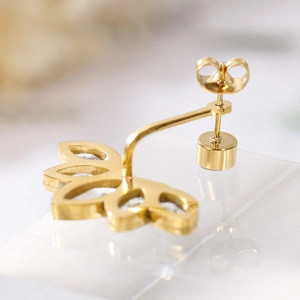 Floral zircon stud earrings in gold plating shown with secure metal butterfly backings