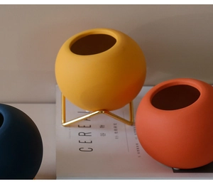 Detail view of colorful Morandi ceramic vases with sleek metal stand on a Cereal magazine