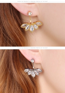 Detail shot of dainty flower-shaped zircon stud earrings shown in gold and silver