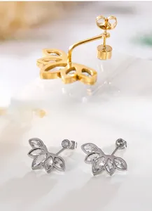 Detailed close-up of zircon lotus stud earrings in polished gold and silver finishes