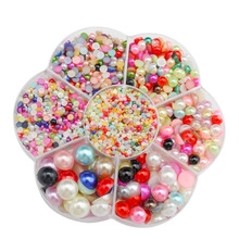 Macro view of colorful 3-5mm faux pearls sorted in a flower-shaped clear storage case
