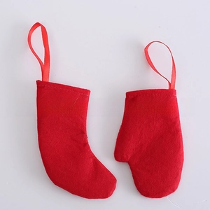 Flat lay of red felt Christmas stocking and mitten ornaments with satin hanging ribbons