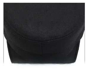 Close-up of wool flat top hat with silver metal logo and precise stitching details