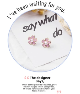 Detail of pink floral earring with white pearl center and elegant gold metal trim