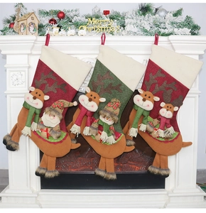 Trois chaussettes de Noël décoratives suspendues à une cheminée blanche festive