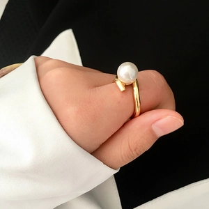 Chic gold twisted open ring with a natural freshwater pearl worn on finger