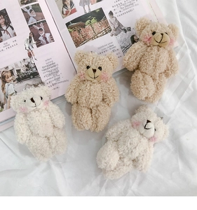 Detail of cute plush bear keychains in beige and light brown with soft fur texture