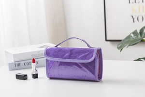 Close-up of purple sequin travel toiletry bag with transparent PVC window and handle