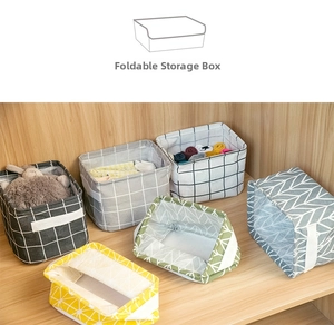 Foldable cotton linen storage bins with side handles organized in a wooden cabinet