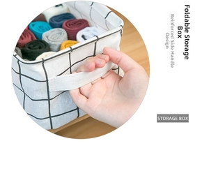 Detail of a foldable cotton linen basket with black grid pattern and reinforced handle