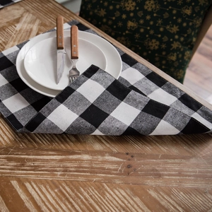 Classic black and white checkered cotton linen table runner on a rustic wooden dining table