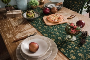 Close-up of golden festive table runner with wooden pizza board and holiday decor