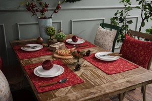 Detailed texture of red festive place mat with golden snowflake and bell patterns