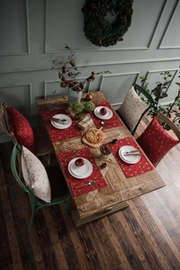 Close-up of red snowflake Christmas placemats and cushions on a rustic wooden dining table